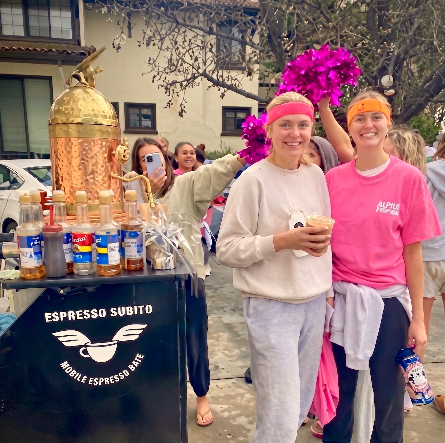 Guests in casual game-day gear enjoying iced coffee at the Espresso Subito cart